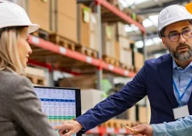 Logistics manager meeting with employees to discuss a spreadsheet